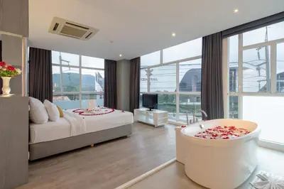 a bedroom with a bed and a tub in a room at DARA Hotel in Phuket Town