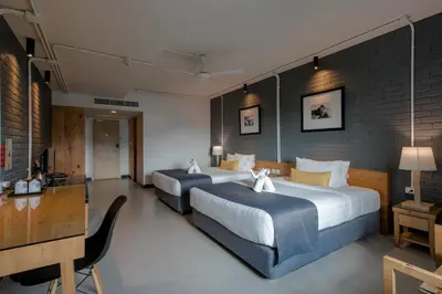 a hotel room with two beds and a desk at DARA Hotel in Phuket Town