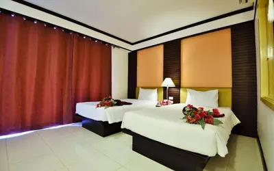 two beds in a hotel room with flowers on them at Phi Phi Arboreal Resort in Phi Phi Don