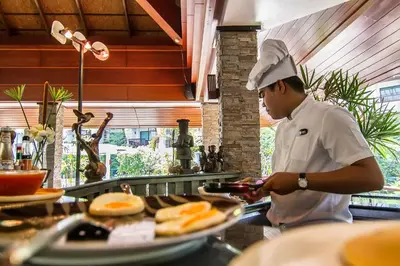 a chef preparing food in a restaurant kitchen at The Elements Krabi Resort - SHA Plus in Klong Muang Beach