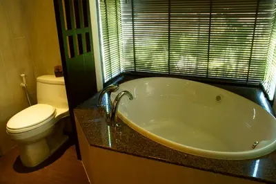a bathroom with a bath tub and a toilet at The Elements Krabi Resort - SHA Plus in Klong Muang Beach