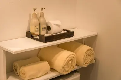 a white shelf with bottles and towels in a bathroom at Aonang All Seasons Beach Resort in Ao Nang Beach