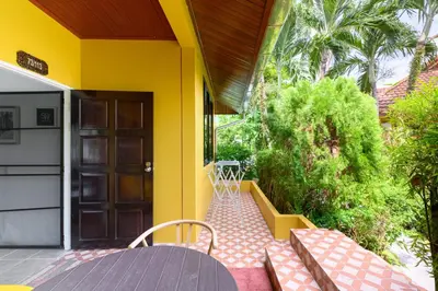 a porch of a house with a table and chairs at Family Bungalow Kamala in Kamala Beach