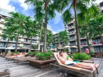 a group of people laying on lounge chairs at a resort at Baan Laimai Beach Resort & Spa - SHA Extra Plus in Patong Beach