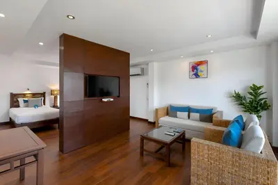 a living room with a couch and a tv at Baan Laimai Beach Resort & Spa - SHA Extra Plus in Patong Beach