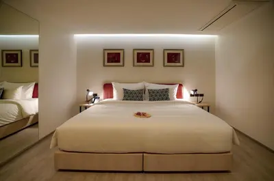 a bedroom with a large white bed with a mirror at Hotel Midtown Ratsada in Phuket Town