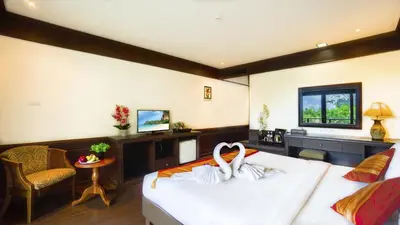 a bedroom with a bed and a couch and a table at Aonang Orchid Resort in Ao Nang Beach