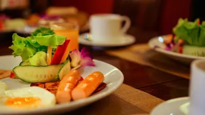 a plate of food with carrots and vegetables on a table at Aonang Orchid Resort in Ao Nang Beach