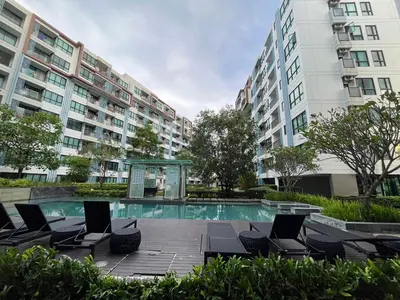 a swimming pool with lounge chairs in front of a building at 1 bedroom Centrio Condominium Phuket Near Central Festival in Phuket town in Phuket Town