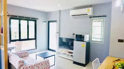 a living room with a refrigerator and a table at The Endless Bangtao Residence 1987 in Bang Tao Beach