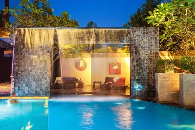 a swimming pool with a water feature in a backyard at Mazi Design Hotel by Kalima in Patong Beach