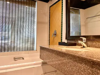 a bathroom with a sink and a tub and a mirror at APK Resort Patong in Patong Beach