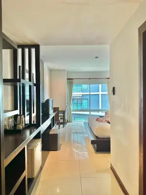 a bedroom with a bed and a large window at APK Resort Patong in Patong Beach