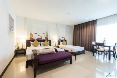 a hotel room with a bed and a table and chairs at Krabi Aquamarine Resort - SHA Plus in Ao Nang Beach