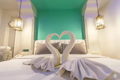 two white swans forming a heart on a bed at The Verandah Aonang in Ao Nang Beach