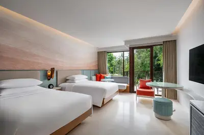 a hotel room with two beds and a tv at Renaissance Phuket Resort & Spa in Mai Khao Beach