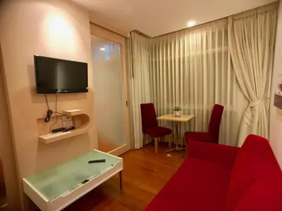 a living room with a red couch and a table at Art Patong by Moloko in Patong Beach