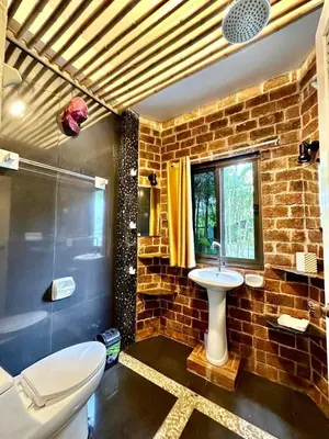 a brick bathroom with a sink and a toilet at Bjou, Cosy Tropical Villa in Rawai Beach