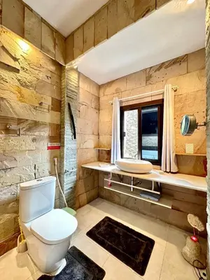 a bathroom with a toilet and a window at Bjou, Cosy Tropical Villa in Rawai Beach