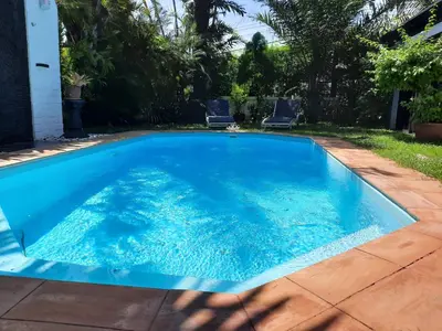 a swimming pool with blue water in a yard at Bjou, Cosy Tropical Villa in Rawai Beach