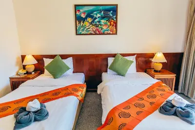 a room with two beds with towels on them at Krabi Sands Resort in Klong Muang Beach