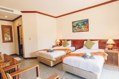 a hotel room with two beds and a table at Krabi Sands Resort in Klong Muang Beach