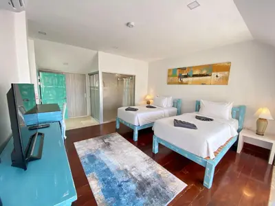 a hotel room with two beds and a television at Baan Ban Dalay in Ao Nang Beach