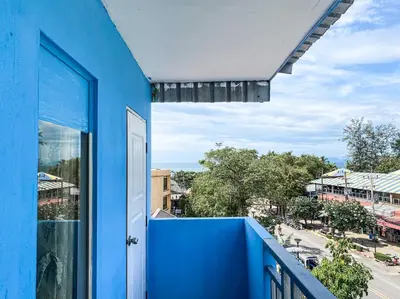 a blue house with a blue balcony with a view of a street at The Palace Aonang Resort in Ao Nang Beach