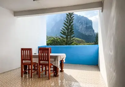 a table and chairs in a room with a view of a mountain at The Palace Aonang Resort in Ao Nang Beach
