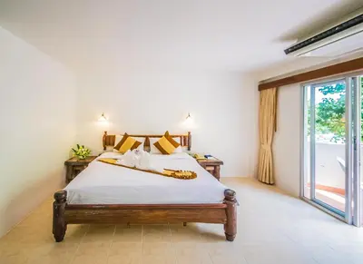 a bedroom with a bed and a large window at Aonang Sunset Hotel - SHA Extra Plus in Ao Nang Beach