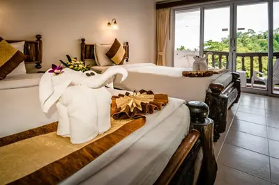 a hotel room with two beds with towels on them at Aonang Sunset Hotel - SHA Extra Plus in Ao Nang Beach