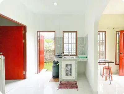 two views of a kitchen with a red door at The Endless Bangtao Residence TV2 AND TV 3 in Bang Tao Beach
