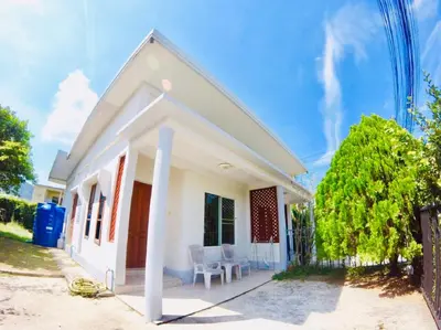 a white house with a chair and a fence at The Endless Bangtao Residence TV2 AND TV 3 in Bang Tao Beach