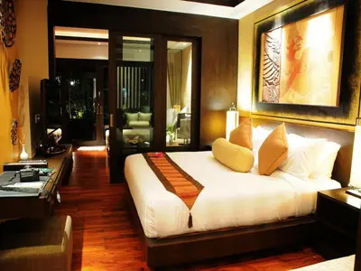 a bedroom with a bed and a living room at Niramaya Villa & Wellness in Ko Yao Noi