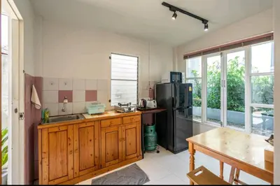 a kitchen with a refrigerator and a sink and a table at The Endless Bangtao Residence ST2 in Bang Tao Beach