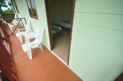 a balcony with two white chairs on a house at Sand Sea House in Phi Phi Don