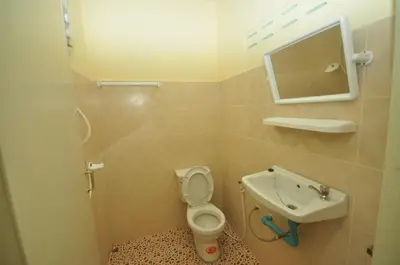 a small bathroom with a toilet and a sink at Sand Sea House in Phi Phi Don