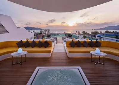 a balcony with couches and a view of the ocean at The Kee Resort & Spa in Patong Beach