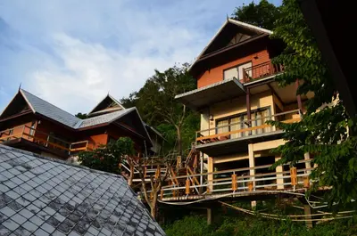 a house with a balcony and a roof at Phitharom PP Resort in Phi Phi Don