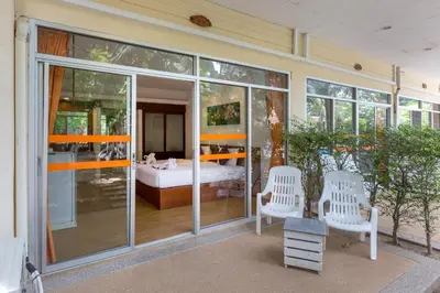 a room with glass doors and a bedroom with a bed at Phuket Sea Resort SHA Extra Plus in Rawai Beach