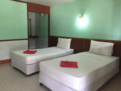 two beds in a room with red towels on them at Scenery Guest House in Phi Phi Don