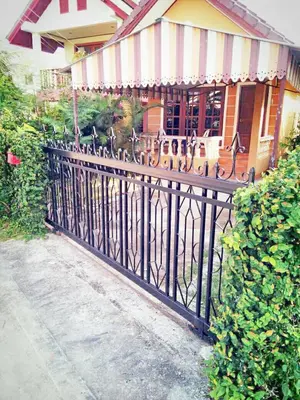 a black iron fence in front of a building at The Endless Bangtao Residence VC 2 in Bang Tao Beach