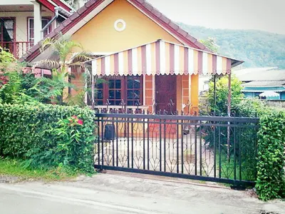 a house with a black gate in front of it at The Endless Bangtao Residence VC 2 in Bang Tao Beach
