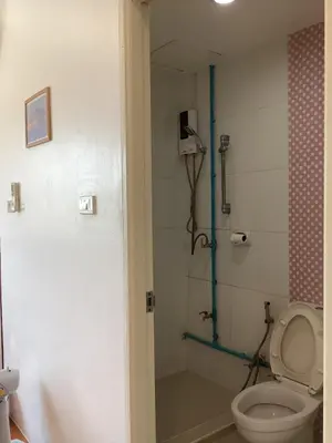 a bathroom with a shower with a toilet and a shower at mom's home in Phuket Town