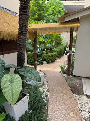 a garden with a walkway next to a building at Mama Beach Residence - Adults Only in Phi Phi Don