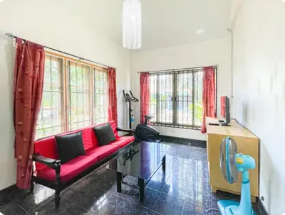 a living room with a red couch and windows at The Endless Bangtao Residence Chat 1 in Bang Tao Beach