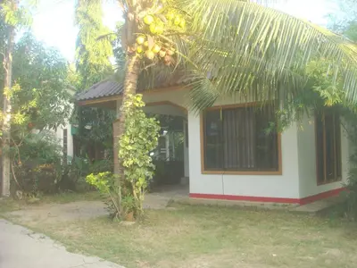 a house with a bunch of fruit hanging from a tree at The Endless Bangtao Residence Chat 1 in Bang Tao Beach