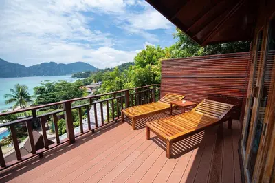 two benches sitting on a deck overlooking the water at Phi Phi The Beach Resort in Phi Phi Don