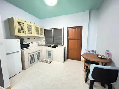 a small kitchen with a table and a refrigerator at The Endless Bangtao Residence Wat 1 in Bang Tao Beach