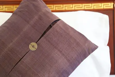 a close up of a brown suit on a bed at Hotel De Karon in Karon Beach